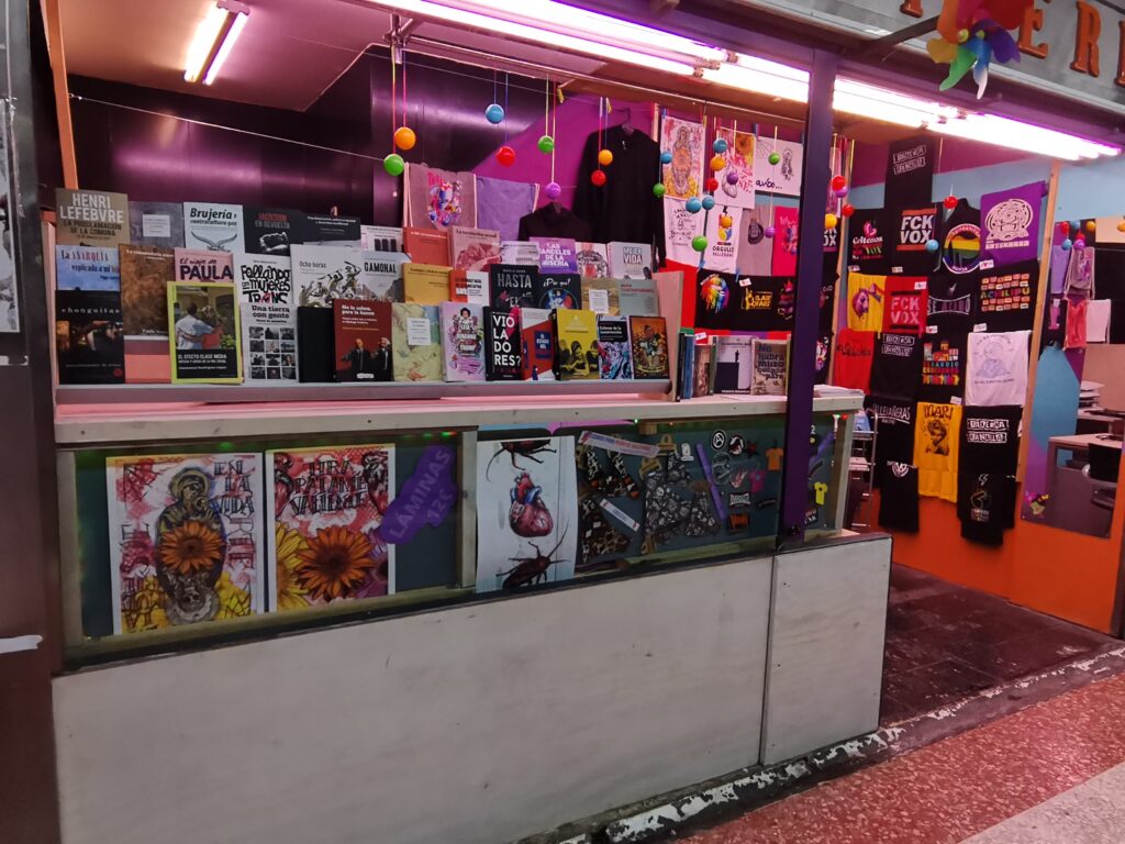 Foto d ela tienda donde se aprecian muchos de los libros y camisetas que vendemos con sus guiños y lemas con sus titulos y tambien los parches y láminas